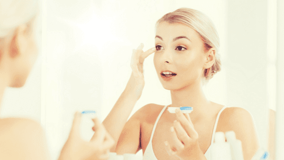 girl putting contact lens in eye